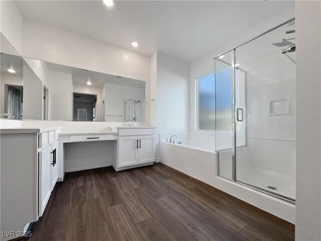 bathroom with vanity, wood-type flooring, and plus walk in shower