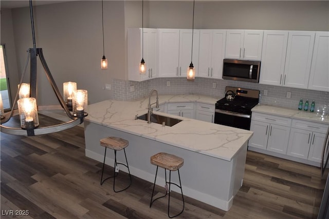 kitchen featuring white cabinetry, sink, stainless steel appliances, kitchen peninsula, and decorative backsplash