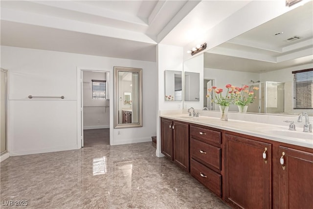 bathroom featuring a shower with shower door and vanity