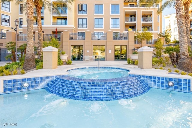 view of pool with pool water feature and a community hot tub