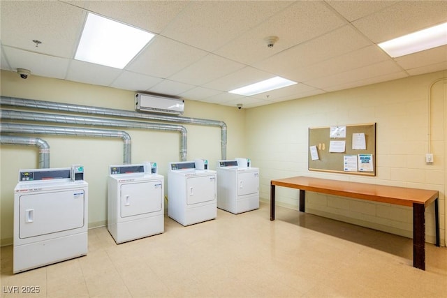 laundry area with washer and dryer and a wall unit AC