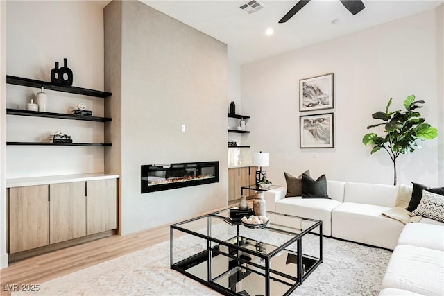 living room featuring ceiling fan and light hardwood / wood-style floors