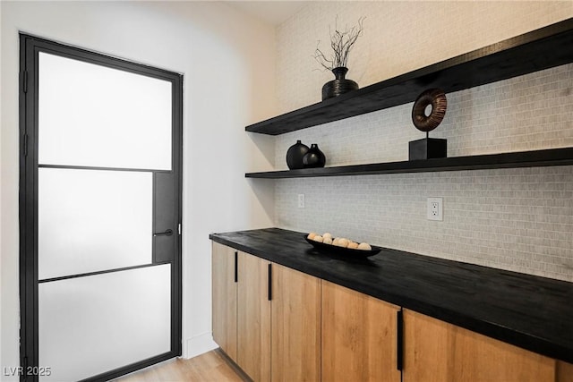 interior space with hardwood / wood-style floors and backsplash