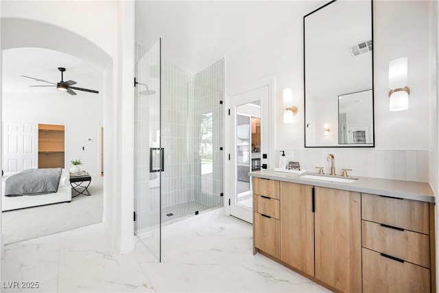 bathroom featuring vanity, a shower with door, and ceiling fan