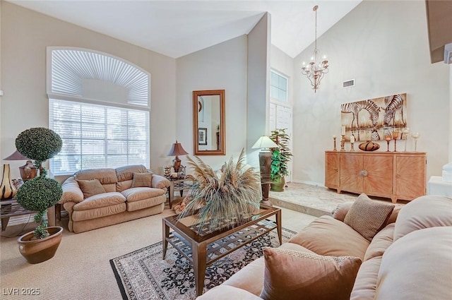 carpeted living room featuring high vaulted ceiling and a chandelier