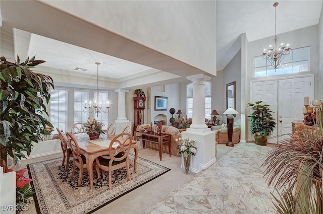 dining area with ornate columns, a high ceiling, and a notable chandelier