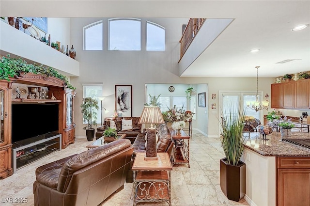 living room with a towering ceiling and an inviting chandelier