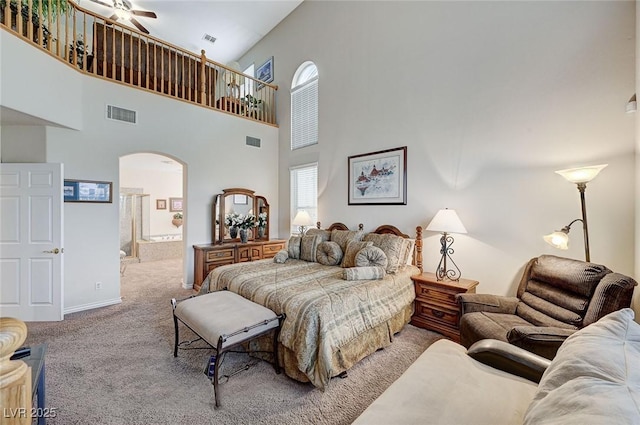 carpeted bedroom with a towering ceiling and ceiling fan