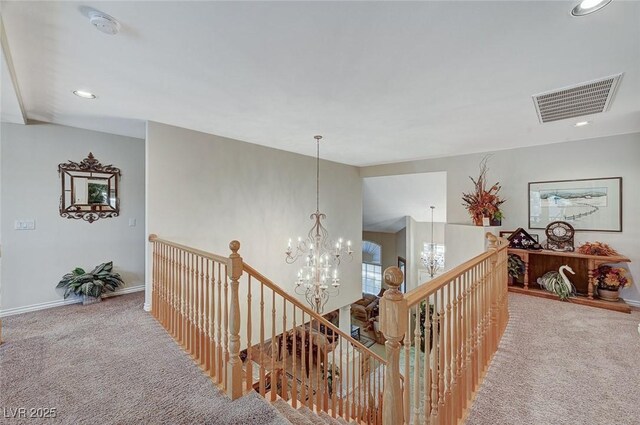 hallway with carpet flooring and a chandelier