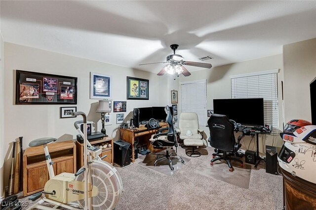 carpeted home office featuring ceiling fan