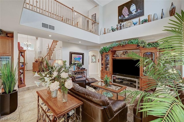 living room with a towering ceiling and an inviting chandelier