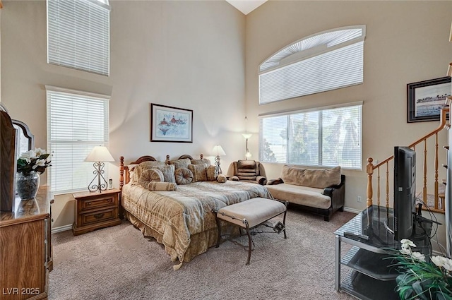 bedroom with a high ceiling and carpet floors