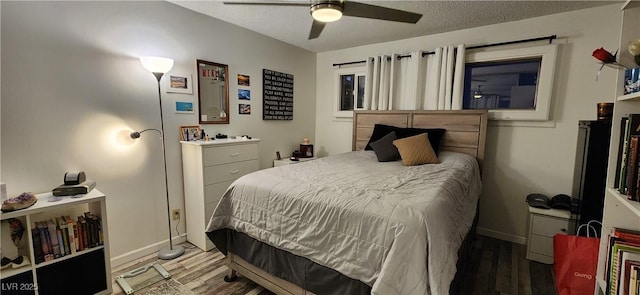 bedroom with hardwood / wood-style flooring, ceiling fan, and a textured ceiling