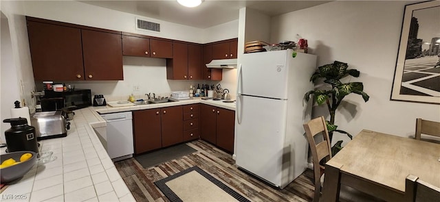 kitchen with light tile patterned floors, white appliances, and sink