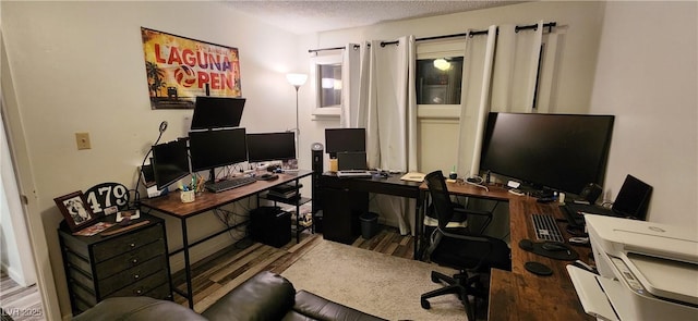 home office with hardwood / wood-style floors and a textured ceiling