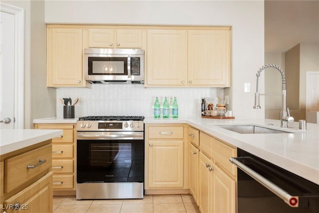 kitchen featuring light tile patterned flooring, light brown cabinetry, sink, stainless steel appliances, and backsplash