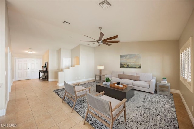 tiled living room with ceiling fan and vaulted ceiling