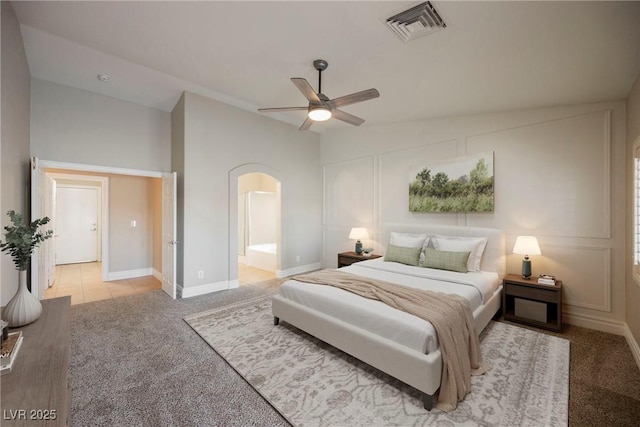 bedroom featuring ensuite bathroom, lofted ceiling, carpet floors, and ceiling fan