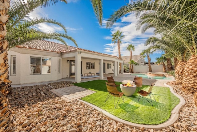 back of property featuring a patio area and a fire pit