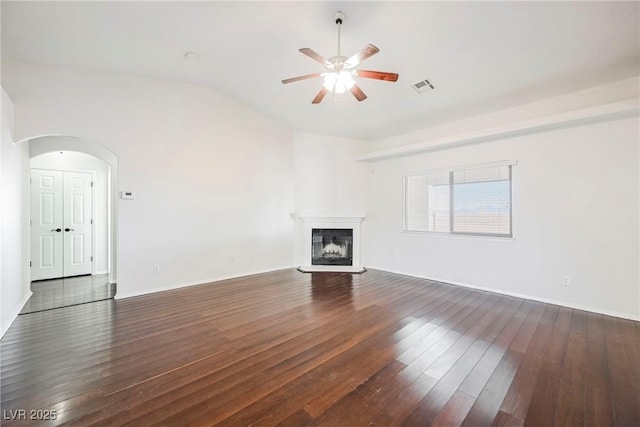 unfurnished living room featuring vaulted ceiling, ceiling fan, and dark wood-type flooring