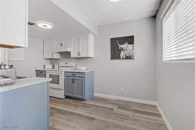 kitchen featuring white electric range oven, baseboards, light wood finished floors, gray cabinetry, and light countertops