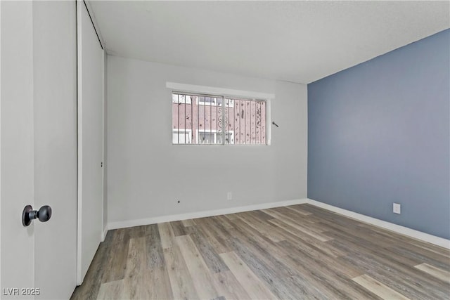 empty room featuring baseboards and wood finished floors