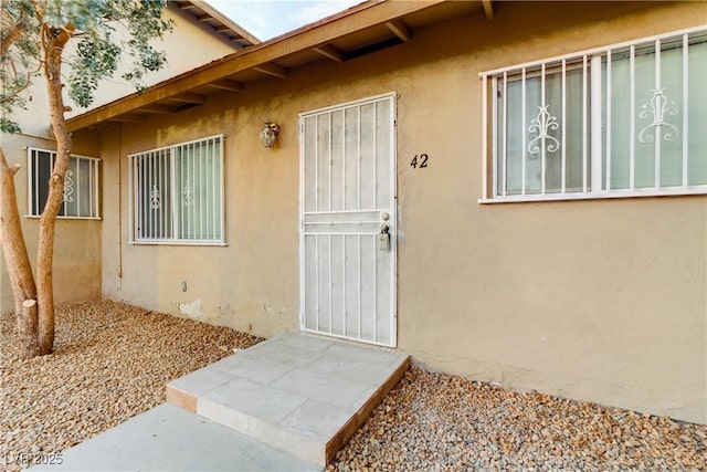 view of exterior entry featuring stucco siding