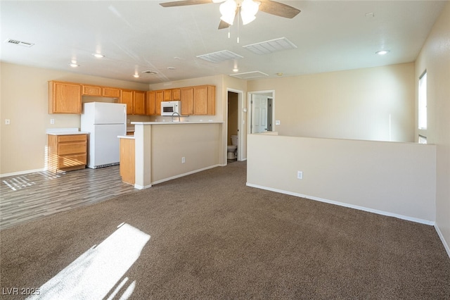 kitchen with ceiling fan, dark carpet, and white appliances