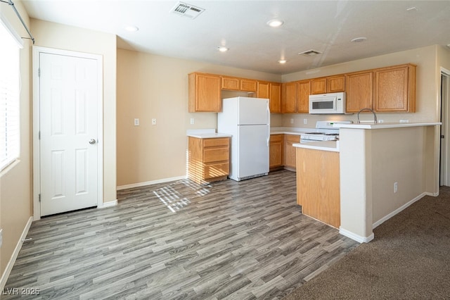 kitchen featuring white appliances and light hardwood / wood-style flooring