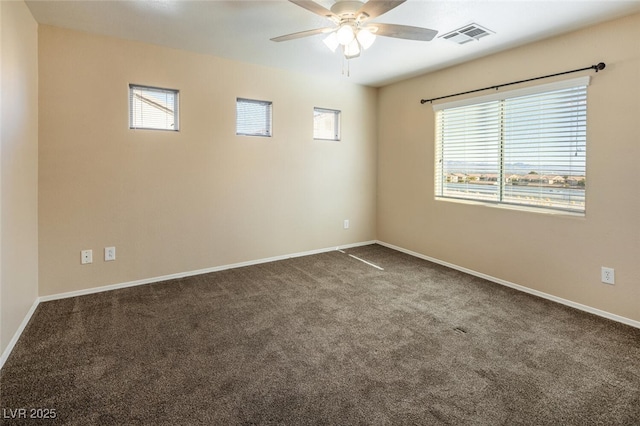 empty room featuring ceiling fan and carpet