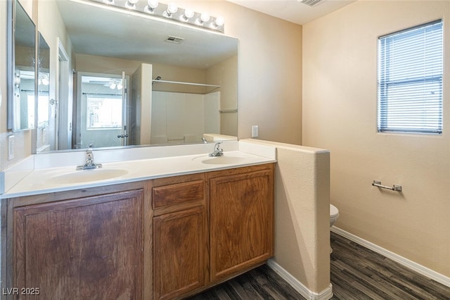 bathroom with a shower, wood-type flooring, vanity, and toilet