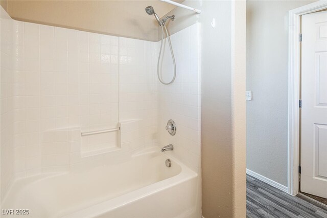 bathroom with wood-type flooring and  shower combination