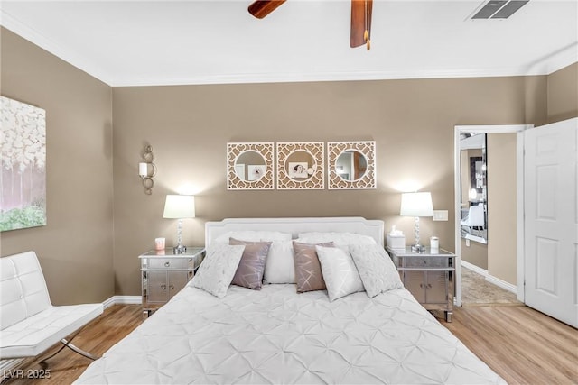 bedroom with light wood-type flooring, ceiling fan, and crown molding