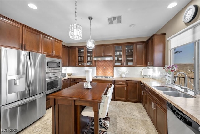 kitchen with visible vents, a sink, decorative backsplash, stainless steel appliances, and under cabinet range hood