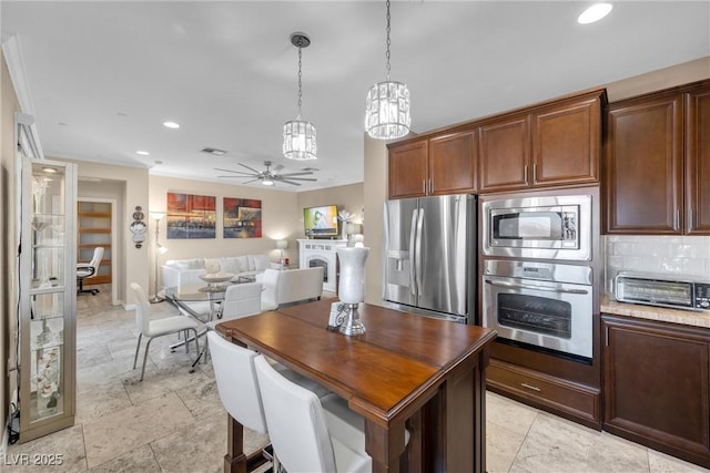 kitchen featuring ceiling fan, decorative light fixtures, backsplash, and stainless steel appliances