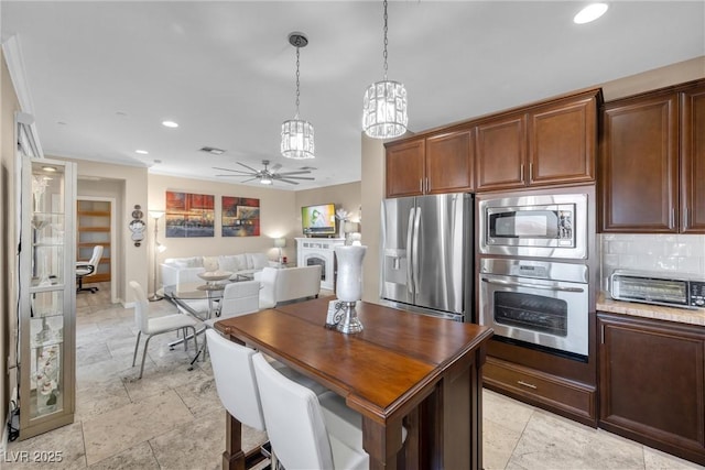 kitchen with recessed lighting, stainless steel appliances, tasteful backsplash, ceiling fan with notable chandelier, and open floor plan
