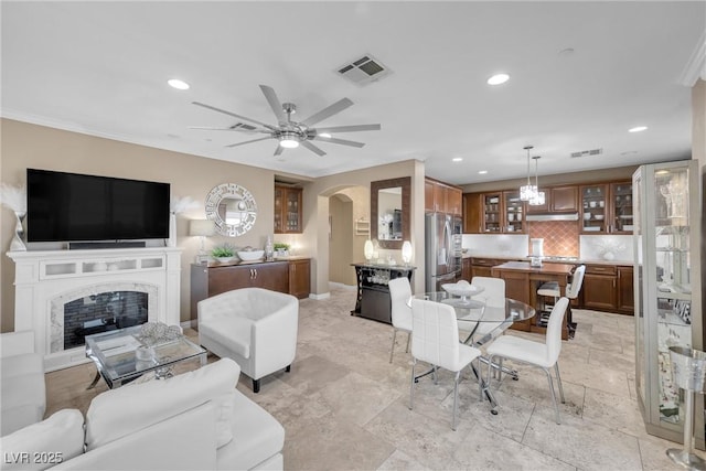 living room with arched walkways, visible vents, recessed lighting, and a fireplace