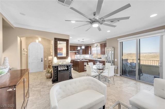 living room with recessed lighting, visible vents, a ceiling fan, and crown molding