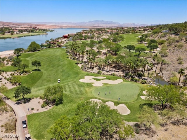 birds eye view of property with golf course view and a water view