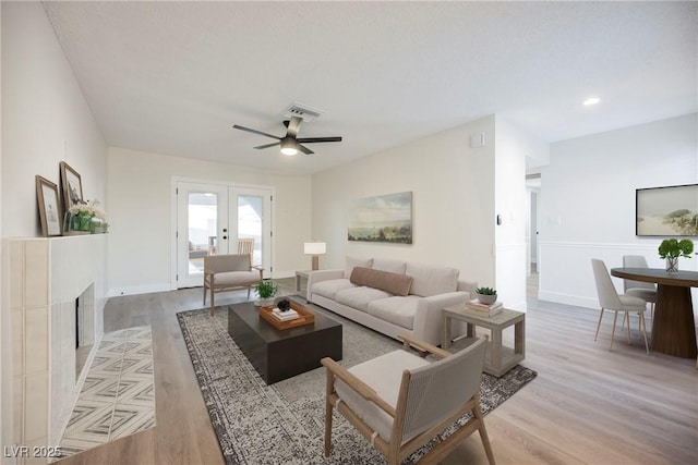 living room with ceiling fan, french doors, and light hardwood / wood-style floors