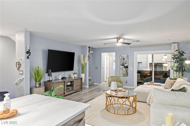 living room featuring light hardwood / wood-style flooring and ceiling fan