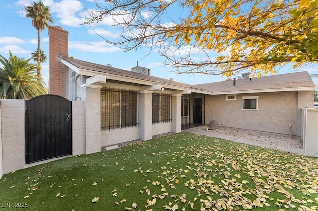 rear view of house featuring a yard