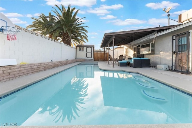 view of pool featuring a shed, an outdoor hangout area, and a patio