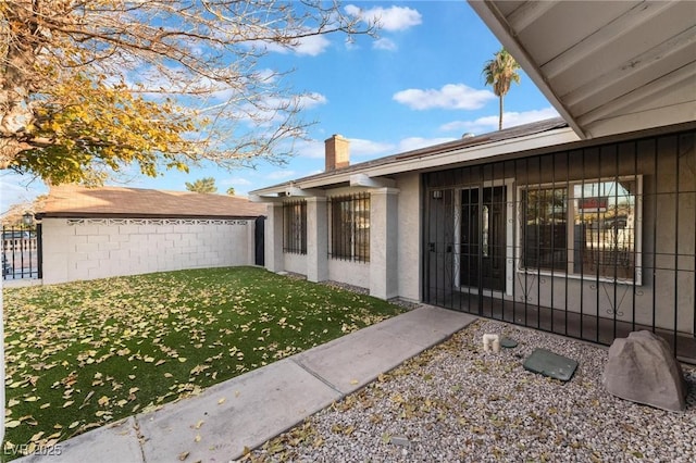 view of exterior entry with a lawn