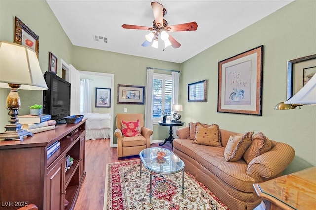 living room with ceiling fan and light hardwood / wood-style flooring