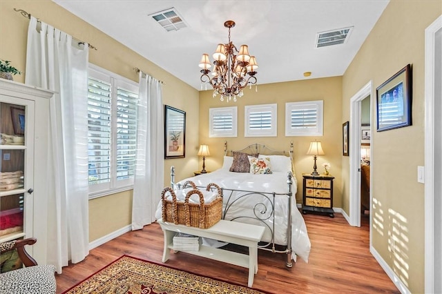 bedroom featuring light hardwood / wood-style flooring and a notable chandelier