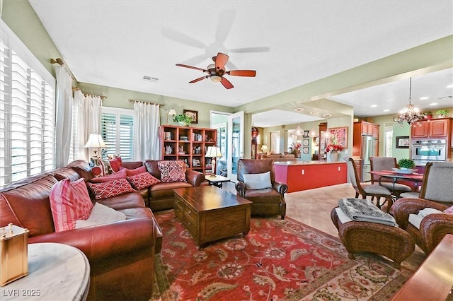 living room with ceiling fan with notable chandelier