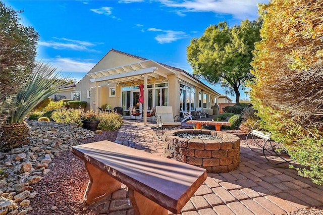 back of property featuring a pergola, a patio, and a fire pit