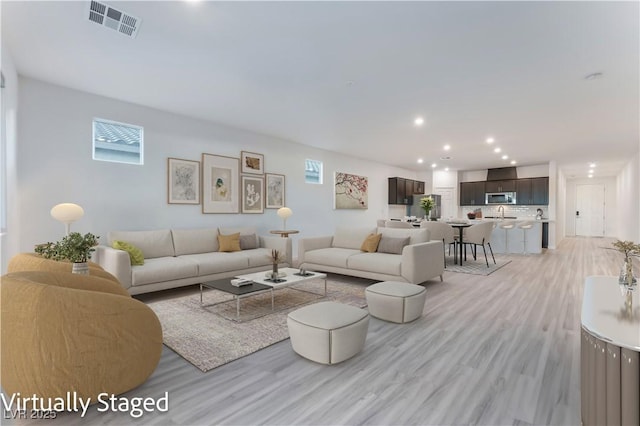 living room featuring visible vents, recessed lighting, and light wood-style floors