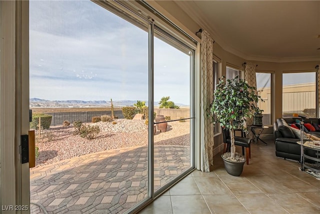 entryway with light tile patterned flooring, ornamental molding, and a mountain view